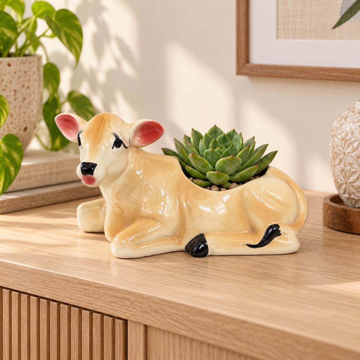 Cow-shaped ceramic planter styled with a succulent on a wooden console