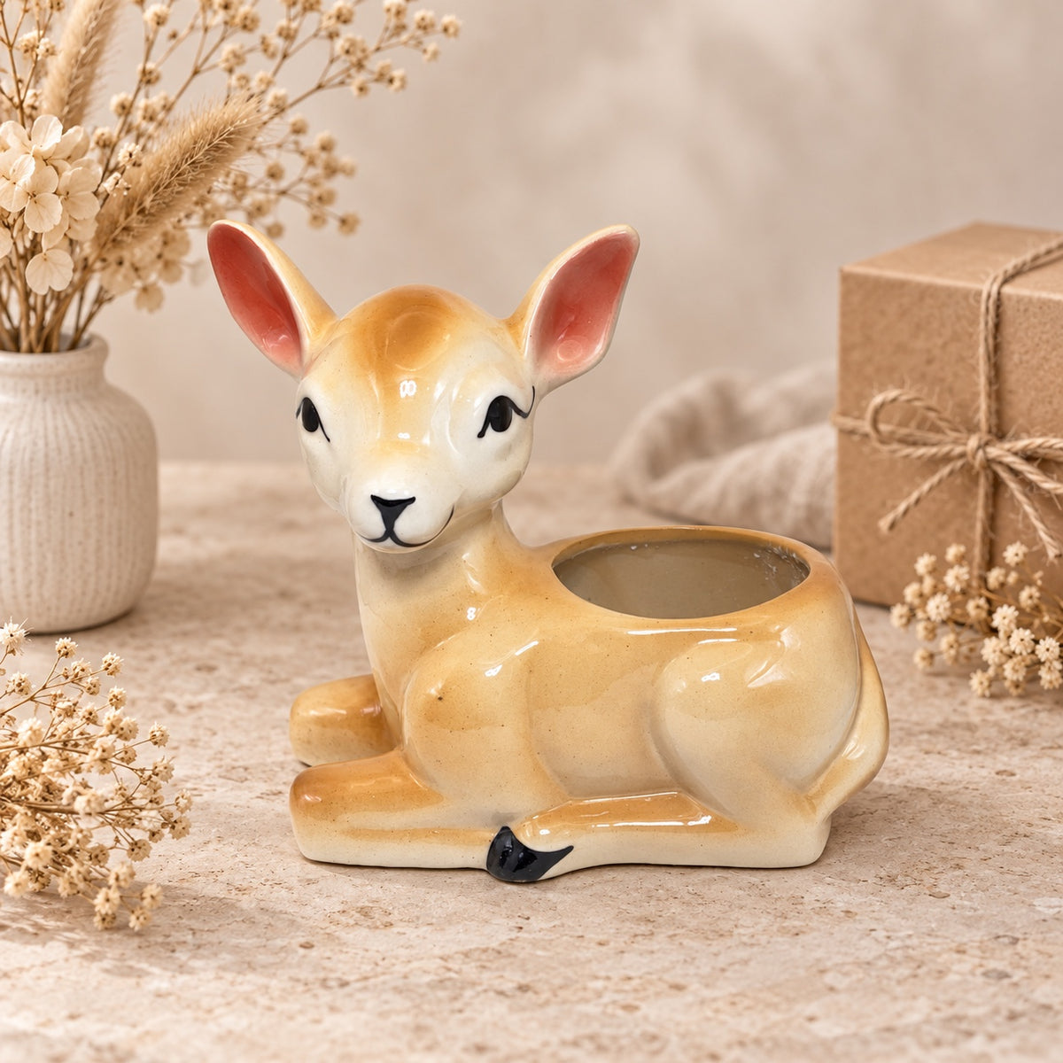Deer shaped ceramic indoor planter styled as warm neutral home decor beside a gift box