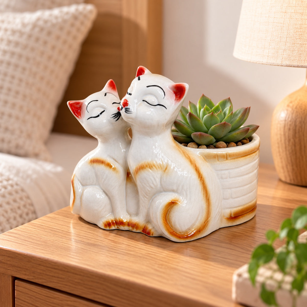 Kissing cats ceramic indoor planter styled with a succulent on a bedside table