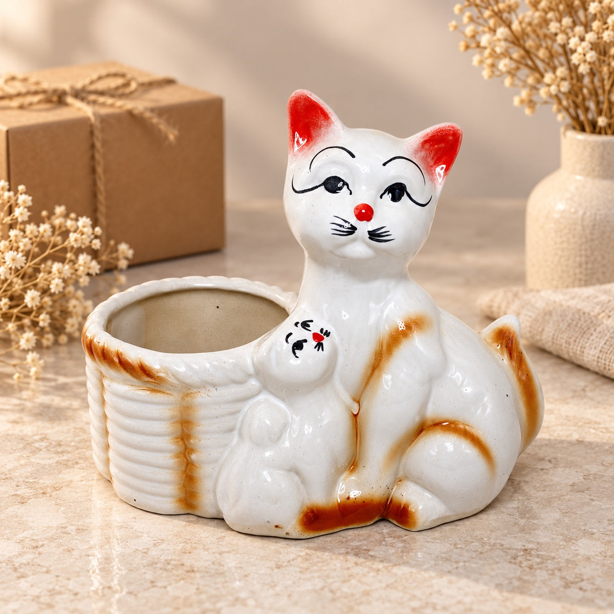 Mother cat and kitten ceramic indoor planter styled as warm home decor beside a gift box